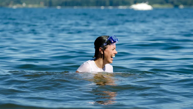 Frau schwimmt in ruhigem Seewasser