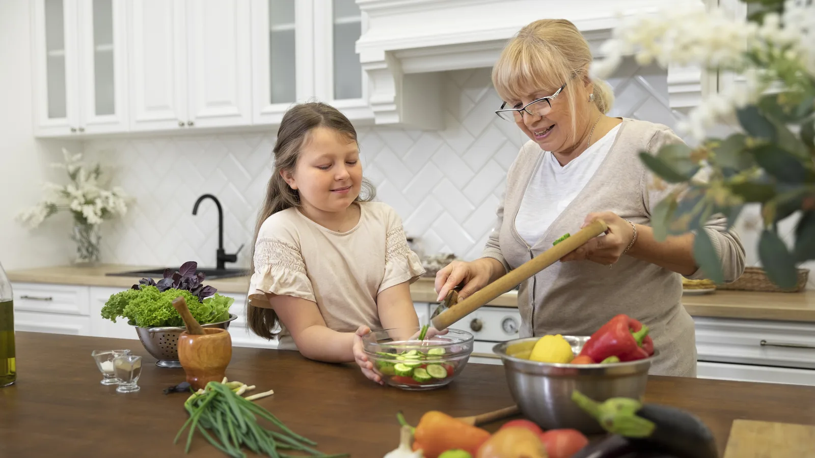 Großmutter und Mädchen bereiten gemeinsam Essen an der Küchenarbeitsplatte zu