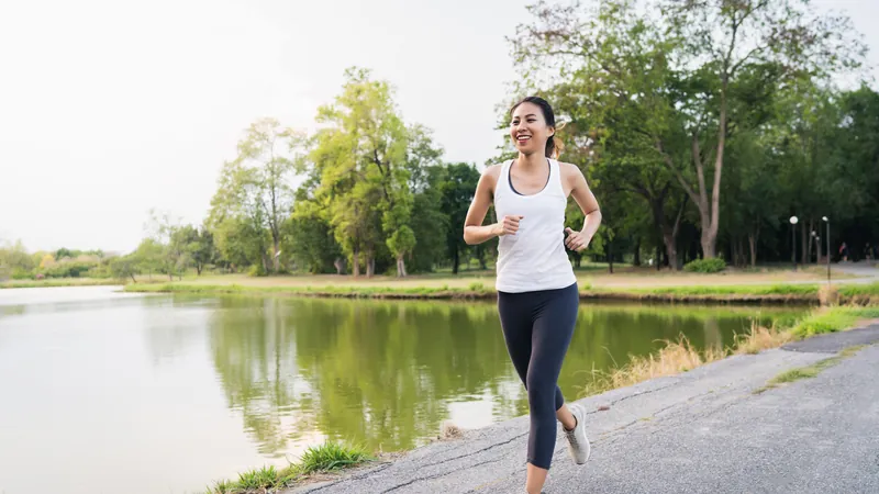 Läuferin joggt morgens an einem See entlang