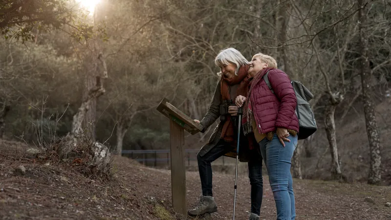 Zwei ältere Frauen wandern auf einem Waldweg
